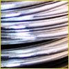 Close-up of shiny, coiled metal wires with a reflective surface and curved lines.