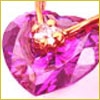 Close-up of a heart-shaped purple gemstone pendant with a gold setting and a small central clear stone.