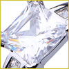 Close-up of a shiny, square-cut diamond set in a silver ring, reflecting light and rainbow hues.
