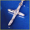 Silver cross pendant with small gemstones on a blue background.