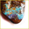 A close-up of a polished stone with brown, blue, and purple colors blending together on its smooth surface.