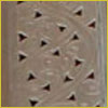Close-up of a textured brown surface with small, triangular cutouts arranged in a repeating pattern.