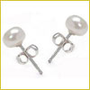 Small pearl stud earrings with silver posts and butterfly backings on a white background.