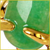 Close-up of a green gemstone held by shiny gold prongs, with a yellow border around the image.