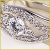 Close-up of a diamond engagement ring with a central stone surrounded by smaller diamonds set in a silver band.