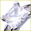 Close-up of a silver ring with a large, square-cut clear gemstone and small side stones, reflecting light.
