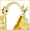 Close-up of a gold hoop earring with a latch-back clasp and decorative details against a white background.