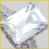 Close-up of a silver ring with a large, rectangular, clear gemstone set in a four-prong setting.