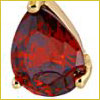 A pear-shaped red gemstone set in a gold prong setting, shown against a white background.