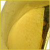 Close-up of a single yellow potato chip inside a yellow container, viewed from above.