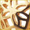Close-up of a golden, intricate geometric pattern with flower-like shapes and cut-out sections.
