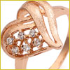 Gold ring with a heart-shaped design, featuring embedded small white gemstones in the center.
