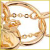 Close-up of a shiny gold chain with decorative links and a floral design against a white background.