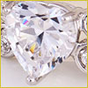 A close-up of a heart-shaped diamond set in a silver ring, reflecting light with colorful highlights.
