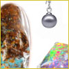 Close-up of a brown and blue stone, a gray ball pendant, and an iridescent object on a white background.