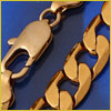 Close-up of a gold chain necklace with a lobster clasp on a blue background.