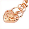 Rose gold heart-shaped locket with floral engravings on a matching chain, photographed close-up.
