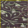 Close-up of dark brown fabric with a pattern of green-outlined, leaf-shaped cutouts and embroidered accents.