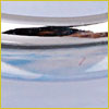 Close-up of a shiny metal surface reflecting light and shapes with a soft blue and silver color palette.