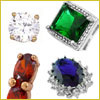Four gemstone rings: a round diamond, a square green gem, a red oval gem, and a blue oval gem, each with different settings.