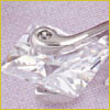 A pair of silver nail clippers resting on a clear, faceted crystal surface against a light purple background.