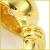 Close-up of a shiny, twisted gold ring with a smooth and polished surface, shown against a white background.