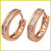 A pair of small gold hoop earrings with embedded clear gemstones, shown on a white background.