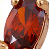 Close-up of an oval-shaped, faceted red gemstone set in a gold prong setting.