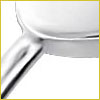 Close-up of a shiny metal pan or pot with a handle, shown against a white background.