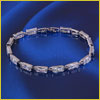 A diamond tennis bracelet with rectangular links displayed on a blue satin background.